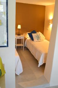 1 dormitorio con 1 cama y 1 mesa con lámpara en Antares, en Sifnos