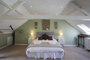 een slaapkamer met een groot bed op zolder bij Thistlebank Townhouse in Whitby