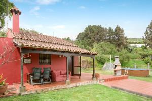 una casa roja con terraza en el patio en La Finca de Teror, en Teror