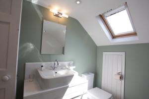 a bathroom with a sink and a mirror and a toilet at Thistlebank Townhouse in Whitby