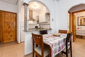 eine Küche und ein Esszimmer mit Tisch und Stühlen in der Unterkunft Bonito Apartamento de dos habitación y piscina in Torrevieja