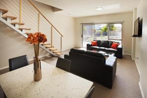 a living room with a vase of flowers on a table at Charlestown Executive Apartments in Newcastle