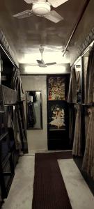 a room with a hallway with a door and racks of clothes at Dormitory in Udaipur
