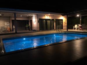 a large swimming pool at night with at Suporn Lakeview in Trakan Phut Phon