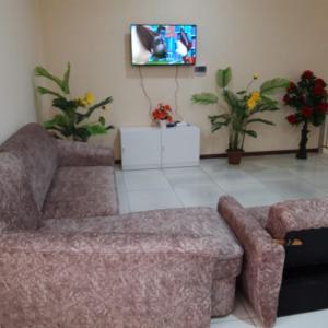 a living room with a couch and a tv at Hostel - NS Prestige in Shymkent