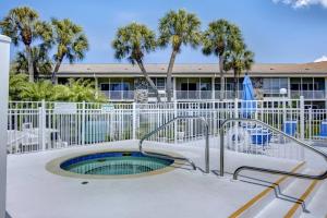 a hot tub in front of a building with palm trees at Kingston Arms 1st Floor in Sarasota