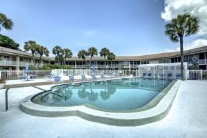 a swimming pool with chairs and a building at Kingston Arms 1st Floor in Sarasota
