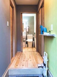 a hallway of a bathroom with a toilet and a doorway at JR Tokyo family room @Otsuka Bovine 101 in Tokyo