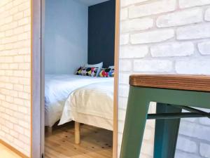 a bedroom with a bed and a brick wall at JR Tokyo family room @Otsuka Bovine 101 in Tokyo