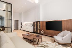 a living room with a white couch and a tv at Plaza Apartments in Opatija