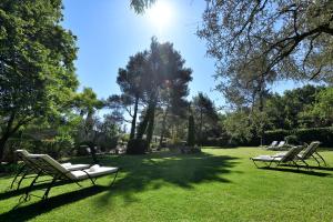 deux chaises longues assises dans un champ d'herbe dans l'établissement Les Mazets de Marie de Jules, à Eyragues