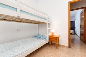 ein Schlafzimmer mit einem Etagenbett und einem Nachttisch in der Unterkunft Bonito Apartamento de dos habitación y piscina in Torrevieja