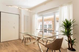 ボローニャにあるMarconi28suitesのダイニングルーム(ガラスのテーブル、椅子付)