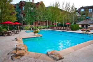 a swimming pool with a patio and tables and umbrellas at 44 Aspen Meadow Drive in Edwards