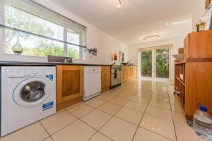 a large kitchen with a washing machine in it at Cois Farraige in Eadargóil