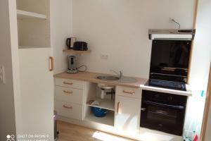 a small kitchen with a sink and a stove at Appartement zen 1er étage in Cherbourg en Cotentin