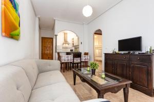 un soggiorno con divano e tavolo di Bonito Apartamento de dos habitación y piscina a Torrevieja