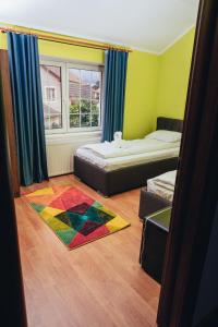 a bedroom with two beds and a colorful rug at GUITAR - Camere de Inchiriat in Sibiu