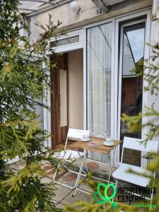 un tavolo e sedie su un patio con finestra di Apartmani Central 2.0 & Free parking a Vrnjačka Banja