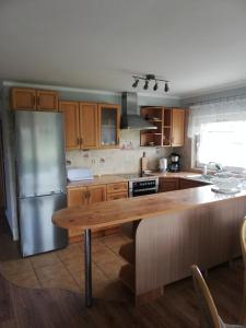 een keuken met een roestvrijstalen koelkast en een houten tafel bij Apartament Bukowy in Kłodzko