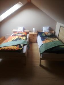 two twin beds in a room with a attic at Apartament Bukowy in Kłodzko