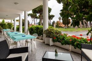 a patio with tables and chairs and flowers at Hotel Il Gabbiano in Sabaudia
