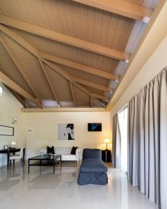 a living room with a wooden ceiling at Ornella Beach Resort & Villas in Syvota
