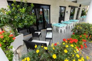 a patio with tables and chairs and flowers at Hotel Il Gabbiano in Sabaudia