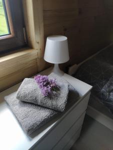 a table with two towels and a lamp on it at Polne domki na Mazurach in Stręgielek