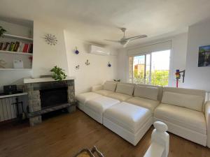 uma sala de estar com um sofá branco e uma lareira em casa en Masnou junto a playa y tren em Masnou