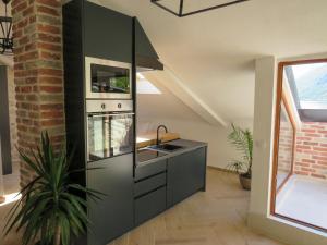 a kitchen with black cabinets and a sink at Mareta loft in Kotor +26 photos