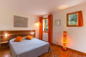 a bedroom with a bed with orange pillows on it at A Casa Aperta in Favalello