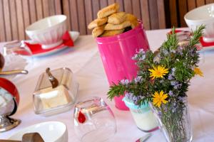 a pink basket filled with bread and flowers on a table at A Casa Aperta in Favalello