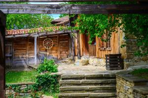 una entrada a una casa de madera con escaleras que conducen a ella en Guest Houses "Zlatna Oresha - Complex" en Zheravna