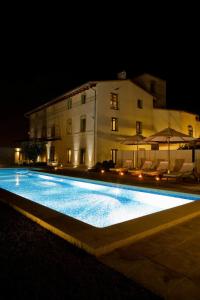 a swimming pool in front of a building at night at La Mozaira in Alboraya