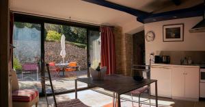 a kitchen and living room with a table and a kitchen and a patio at Le Clos des Amandiers in Simiane-la-Rotonde