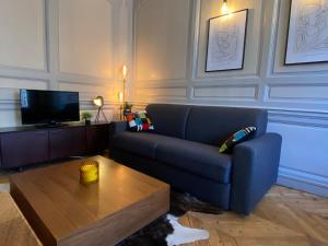 a living room with a blue couch and a coffee table at Les Calins d'Honfleur in Honfleur