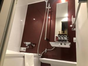 ein Bad mit einem Waschbecken und einem Spiegel in der Unterkunft Gomax (Adult Only) in Yokohama