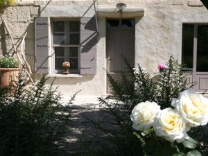 une maison avec des roses blanches devant une porte dans l'établissement Mas de la Forge, à Arles