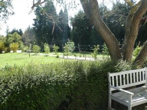 a white park bench sitting next to a tree at Mas de la Forge in Arles