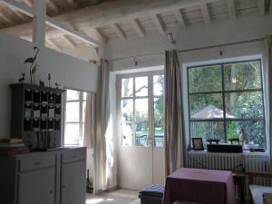 a living room with a large window and a table at Mas de la Forge in Arles