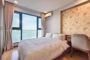 a bedroom with a large bed and a large window at Moon West Lake Hotel & Residence in Hanoi