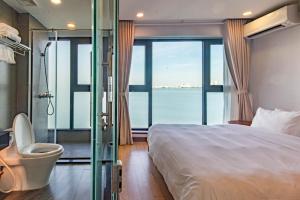 a bedroom with a bed and a bathroom with a window at Moon West Lake Hotel & Residence in Hanoi