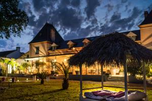 un complexe avec un grand bâtiment doté d'un parasol dans l'établissement BOUTIK Hotel O'Domaine, à Chis