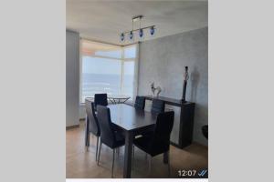 a dining room with a table and chairs and the ocean at Apartamento Angela in Villajoyosa