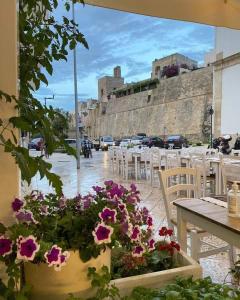 a patio with tables and chairs and purple flowers at Mediterraneo Camere in Otranto