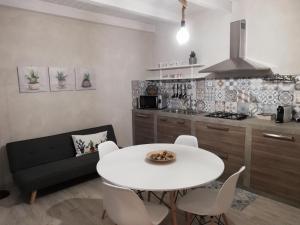 una cucina con tavolo e tavolo e sedie bianchi di Casa Opuntia Rosolini a Rosolini