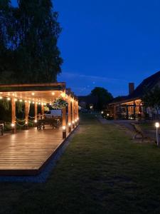 a wooden deck with lights on it at night at Osada Laskowo, Ośrodek Laskowo domki nad jeziorem in Laskowo