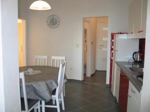 una cucina e una sala da pranzo con tavolo e frigorifero di Apartmani Kunteja a Pag