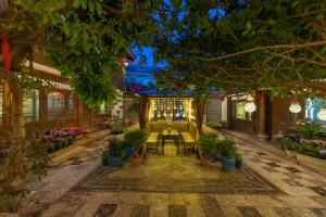 um jardim interior com uma mesa e vasos de plantas em Lijiang Gui Yuan Tian Ju Guesthouse em Lijiang